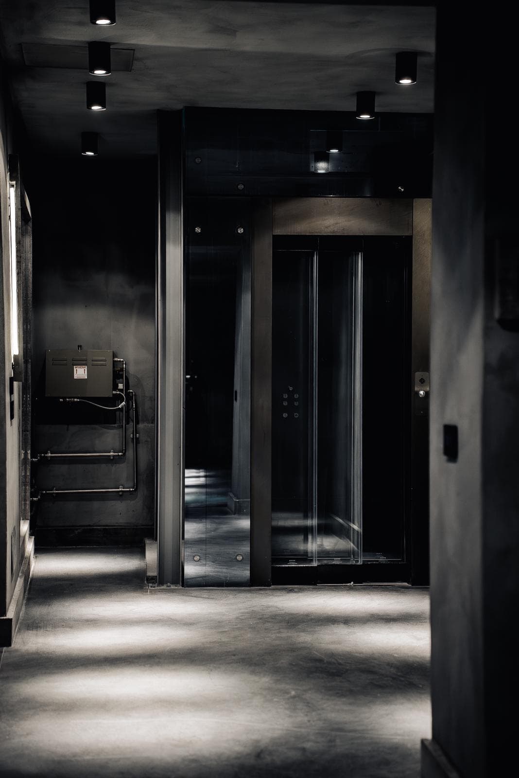 Corridoio interno BAKR con ascensore in acciaio nero